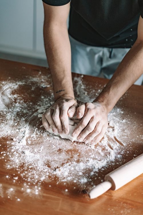 Baker holding a pot of flour in a home kitchen